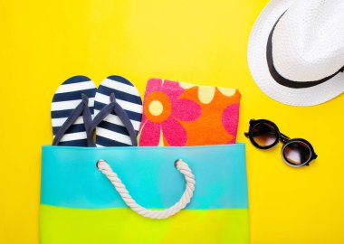 Sarı bir arka plan üzerinde şık plaj aksesuarları