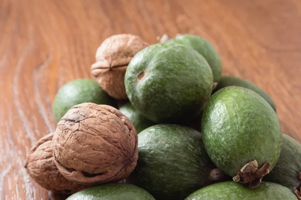 Feijoa meyve ve ceviz ahşap arka plan üzerinde