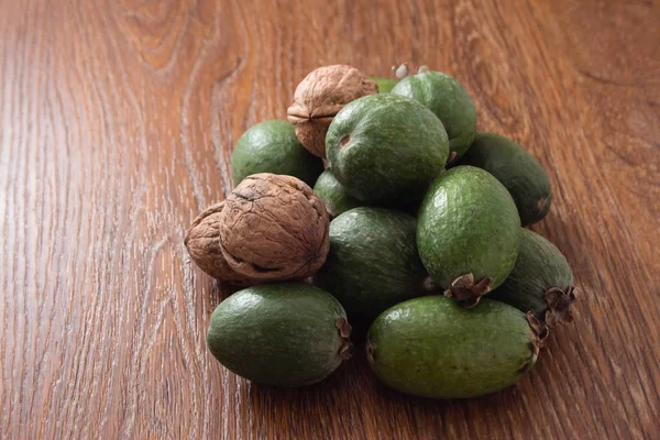 Feijoa meyve ve ceviz ahşap arka plan üzerinde