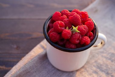 Bir demir kupa içinde ahududu taze çilek 