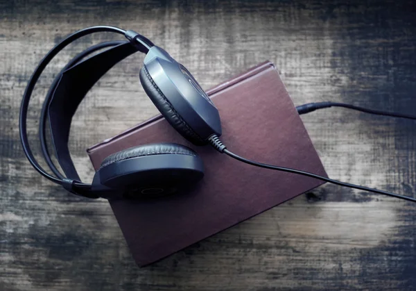 Libros y auriculares en grunge superficie madera. —  Fotos de Stock