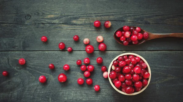 Φρέσκο κόκκινο δάσος cranberry σε ξύλινο Στρογγυλό μπολ με ένα ξύλινο κουτάλι — Φωτογραφία Αρχείου