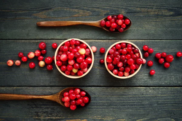 Bosque rojo fresco arándano en tazones redondos de madera con una cucharas de madera — Foto de Stock