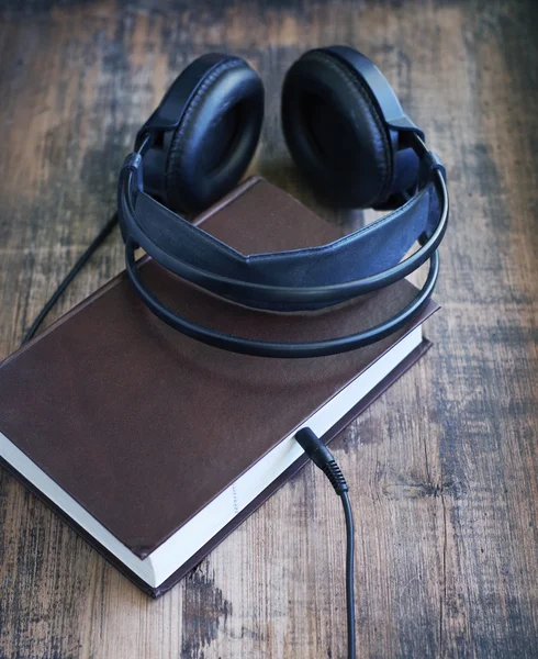 Libros y auriculares en grunge superficie madera. —  Fotos de Stock