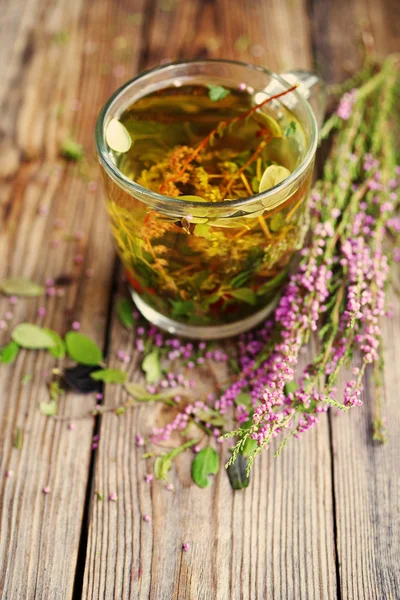 Herbal tea in a transparent glass mug and forest herbs