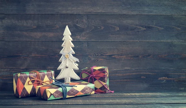 Cajas festivas en papel colorido con un árbol de Año Nuevo decorativo de madera —  Fotos de Stock