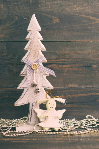 Árbol de Navidad decorativo festivo y un ángel de juguete sobre un fondo de madera en color vintage . —  Fotos de Stock