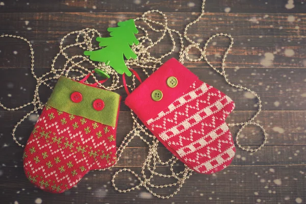 Mitones festivos con un árbol de Año Nuevo decorativo sobre un fondo de madera . —  Fotos de Stock