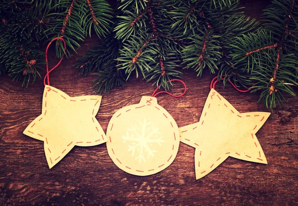Juguetes decorativos de papel de Navidad con ramas de abeto sobre un fondo de madera . — Foto de Stock