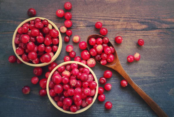 Bosque rojo fresco arándano en una ronda de tazones de fuente con una cuchara de madera — Foto de Stock