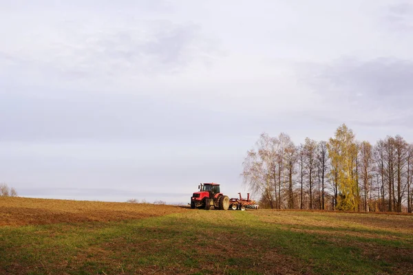 Traktor i fältet plogar jorden på hösten — Stockfoto