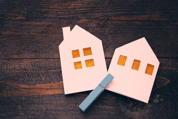 Dwa domki letniskowe z białej księgi w sprawie drewniane tła. Symbolem domu, rodziny, przytulność. — Zdjęcie stockowe