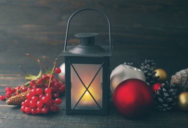 Ahşap arka plan üzerinde koniler ile Noel lamba ve cam küreler. 