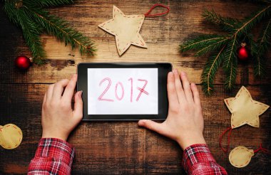 Tablet Pc elinde tutan çocuk. Köknar ağacı dalları ile Noel süsleri ve 2017 bir yastık üzerinde bir metin. 