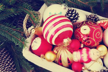 Renkli cam oyuncak ve topları, koniler, dekorasyon ve hediyeler ahşap arka plan ile sepet. Noel ve yeni yıl arka plan. 