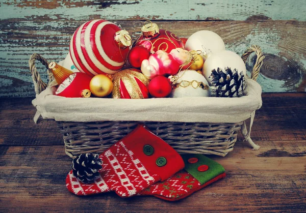 Cesta com brinquedos de vidro coloridos e bolas, cones, decoração e presentes em fundo de madeira. Natal ou Ano Novo fundo . — Fotografia de Stock