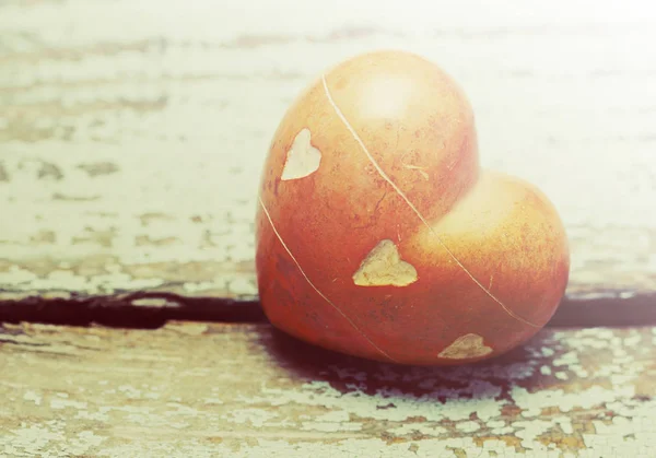 Coração com pedras em um velho fundo de madeira . — Fotografia de Stock