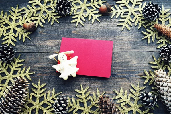 Sfondo natalizio in legno con fiocchi di neve decorativi, pigne e auto rossa vuota — Foto Stock