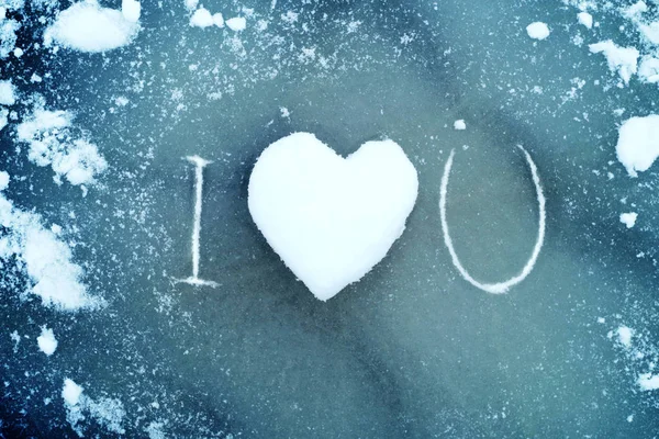 Hart van sneeuw op het ijs. Hart van de sneeuw en de tekst "I love you". — Stockfoto