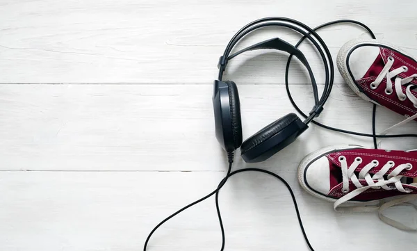 Concepto con zapatillas claret y auriculares negros — Foto de Stock