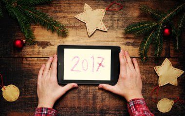 Tablet Pc elinde tutan çocuk. Köknar ağacı dalları ile Noel süsleri ve 2017 bir yastık üzerinde bir metin. 