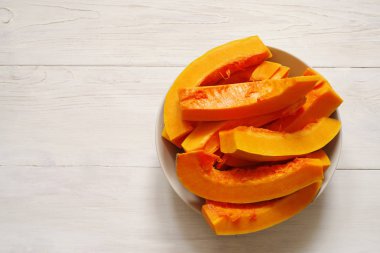 Ahşap beyaz bir yüzeye bir tabağa sulu kabak dilimleri