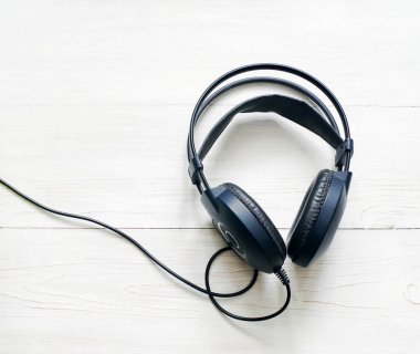 Ahşap arka planda siyah kulaklıklar.