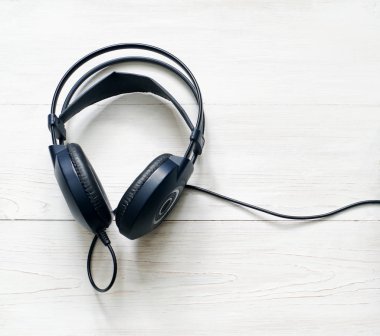 Ahşap arka planda siyah kulaklıklar.