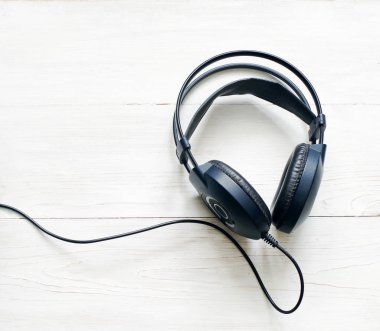 Ahşap arka planda siyah kulaklıklar.