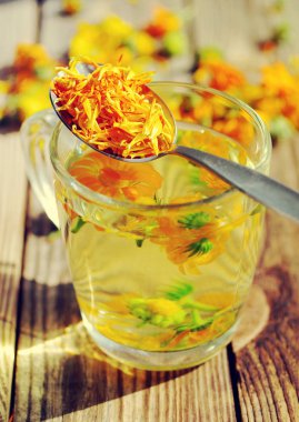 Kadife çiçeği bir şeffaf cam kupa çiçek bitkisel çay.