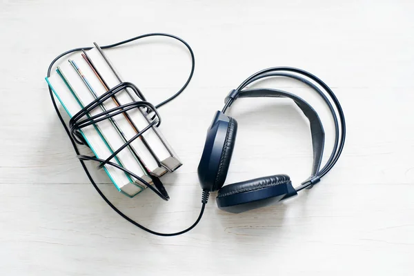 Bücher und Kopfhörer auf hölzerne weiße Fläche. — Stockfoto