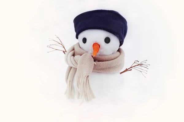 Kleiner Schneemann mit Mütze und Schal auf Schnee im Winter. — Stockfoto