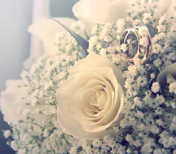 Обручальные кольца на букете кремовых роз — стоковое фото