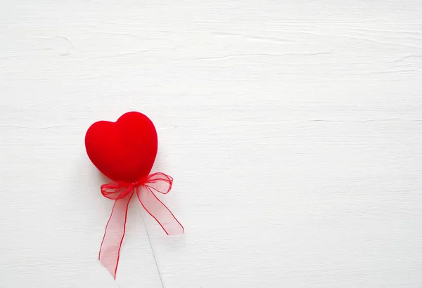 Coração vermelho sobre um fundo branco de madeira. Cartão romântico. — Fotografia de Stock