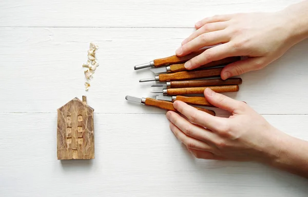 Wooden house och allvarligare svarvmejslar med Mästarens händer — Stockfoto