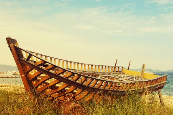 Vecchia barca abbandonata sulla spiaggia contro il mare — Foto Stock