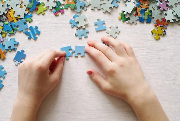 Zagadki. Dziecko ręką krotnie puzzle — Zdjęcie stockowe