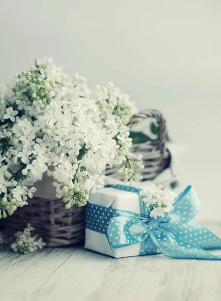 Bouquet d'un lilas blanc dans un panier et un coffret cadeau — Photo