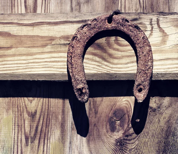 Viejo herradura oxidada una vieja tabla de madera — Foto de Stock