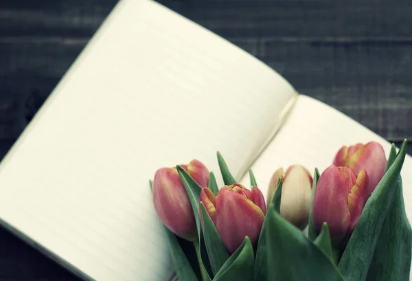 Ramo de tulipanes y cuaderno abierto en blanco —  Fotos de Stock