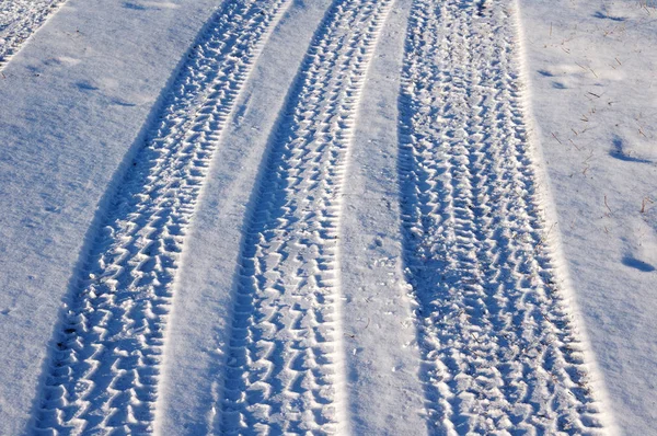 Zakole ślady od opon samochodowych na śniegu. — Zdjęcie stockowe