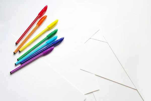 Bright colored pens on sheets of white paper — Stock Photo, Image