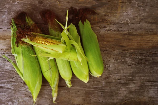 Eski ahşap yüzey üzerinde taze mısır koçanı