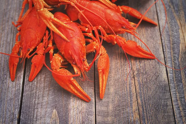 Écrevisses rouges bouillies sur un fond en bois — Photo