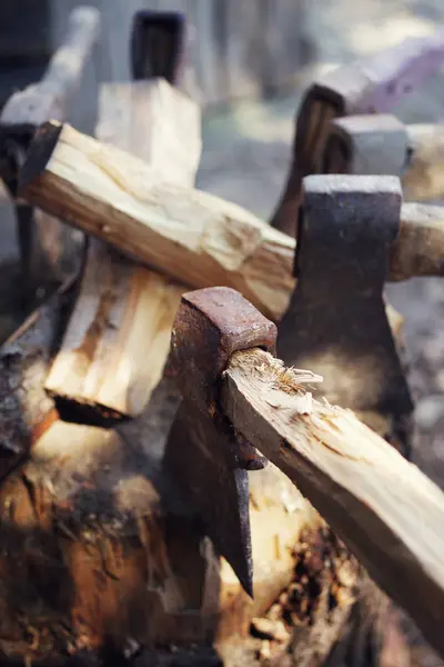 Old axes in a woodpile with chipped firewood. — Stock Photo, Image