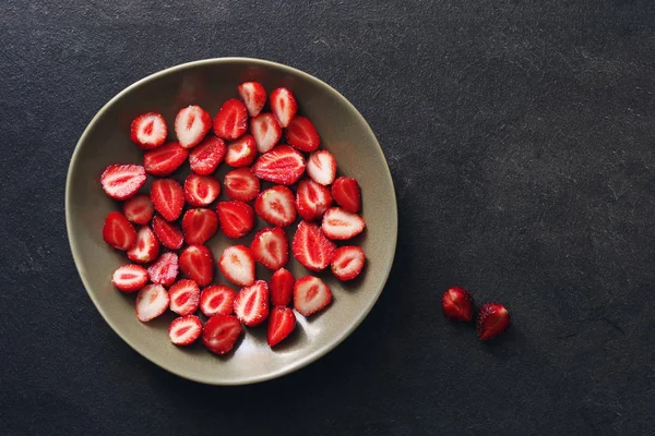 Las bayas jugosas la fresa en el plato sobre la superficie oscura —  Fotos de Stock