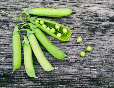 Eski bir ahşap yüzey üzerinde yeşil bezelye Pod