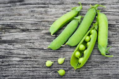 Eski bir ahşap yüzey üzerinde yeşil bezelye Pod