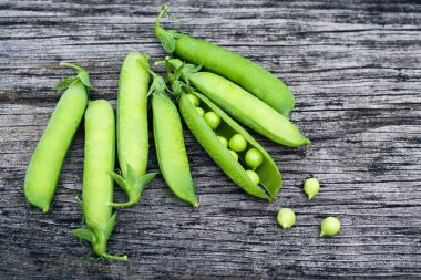 Eski bir ahşap yüzey üzerinde yeşil bezelye Pod