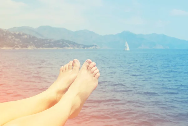 Vrouwelijke voeten op een strand tegen de zee in een zonnige zomerdag — Stockfoto